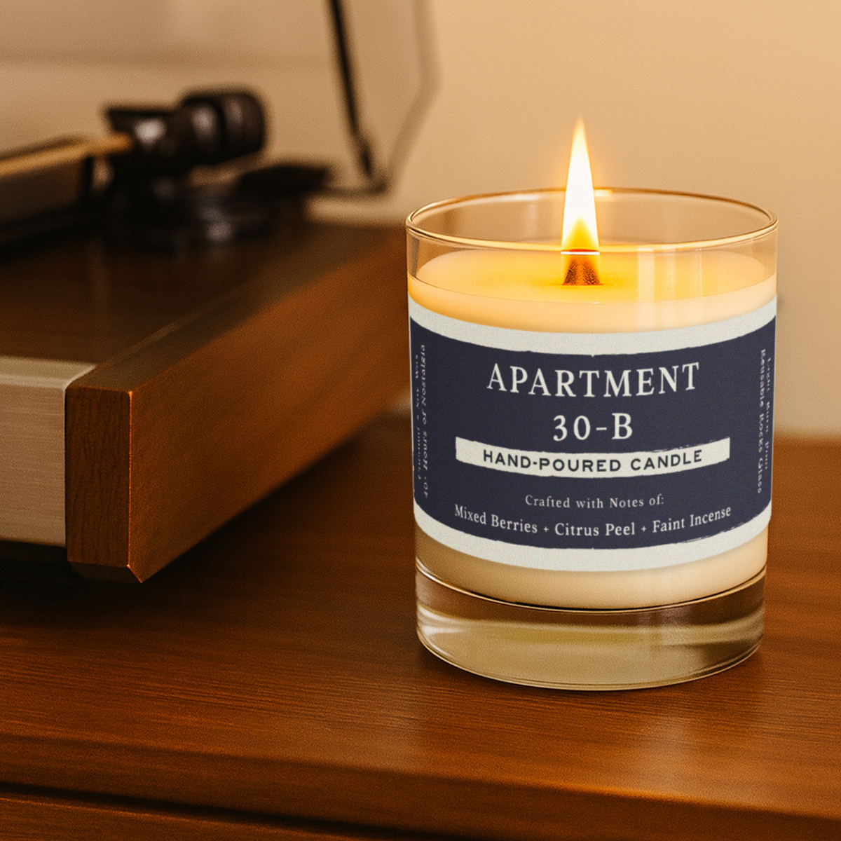 Hand-poured candle labeled 'Apartment 30-B' with its packaging on a gray background